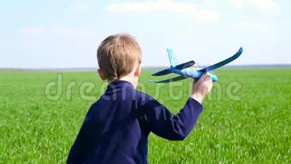一个小男孩拿着一架玩具飞机描绘了这架飞机摄像机跟着正在运行的孩子快乐的孩子在玩视频的预览图