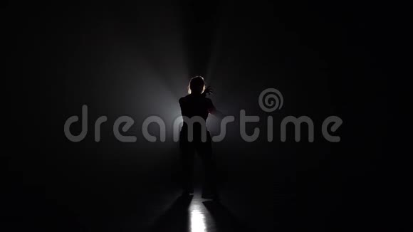 女性在黑暗中练习卡波伊拉对抗灯光聚光灯慢动作视频的预览图