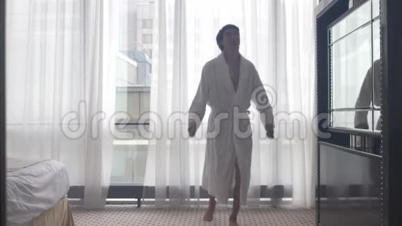 年轻人穿着浴袍在酒店房间跳舞视频的预览图