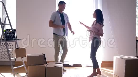 幸福的生活在新房子里在修理后快乐的男朋友和女孩在搬进公寓时快乐地跳舞视频的预览图