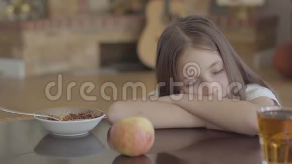 可爱的熟睡孩子的肖像桌子上的食物和长头发的小女孩睡在上面视频的预览图
