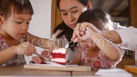 可爱的亚洲小女孩和她的家人在咖啡馆里吃桑葚蛋糕视频的预览图