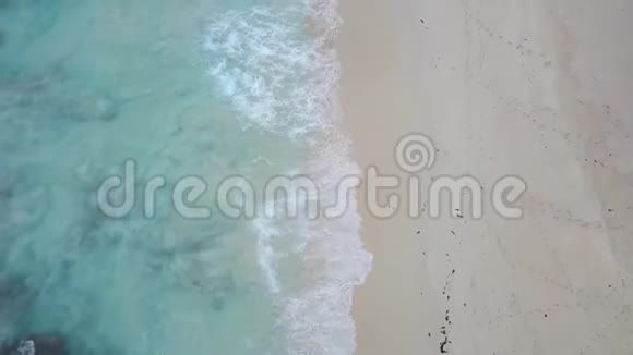 垂直拍摄沿海滩无人机拍摄海浪洗白沙塞岛4K镜头视频的预览图