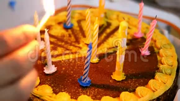 人类的双手点燃了厨房桌子上美丽美味的生日蛋糕上的蜡烛视频的预览图