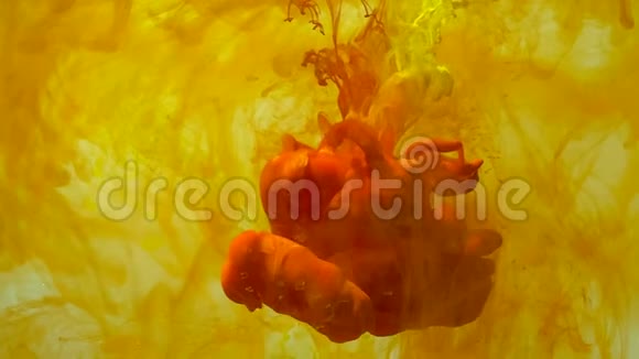黄色和橙色的水彩颜料在水中漂浮视频的预览图