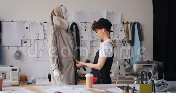 在现代工作室工作的女设计师为模特穿上服装视频的预览图