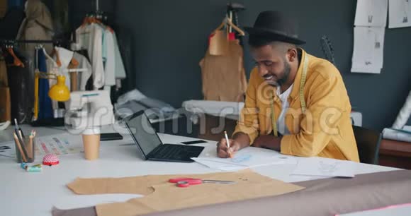 男时装设计师用笔记本电脑画服装创造时尚服装视频的预览图