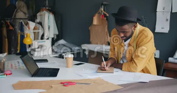有才华的时装设计师用铅笔微笑在笔记本上做笔记视频的预览图