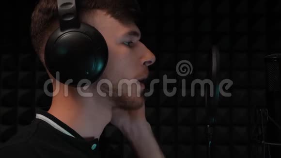 帅哥特写在专业音乐工作室录音男歌手戴着耳机对着麦克风唱歌视频的预览图