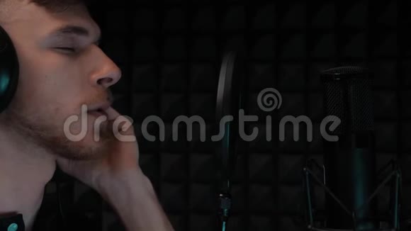 英俊的唱歌男孩留胡子在专业录音室排练流行男艺术家录音声音慢动作视频的预览图