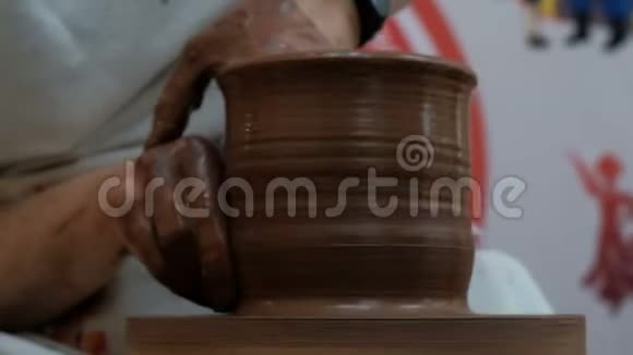 陶工在陶工的车轮上用陶工具塑造粘土制品用现代手表特写女性手视频的预览图