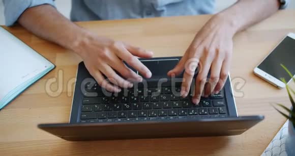 室内桌上笔记本电脑键盘打字的近距离高角度视角视频的预览图