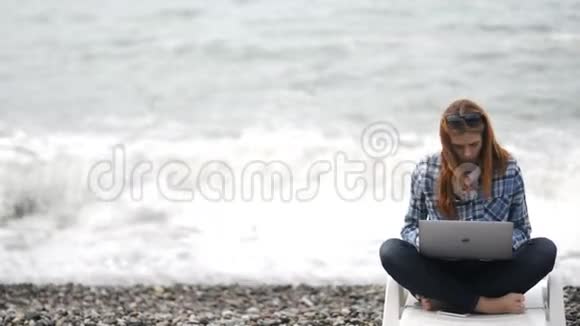 清晨女人随意地坐在海滩上工作视频的预览图