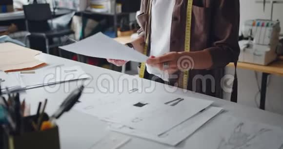 服装设计师拿着服装图纸在工作室创作服装视频的预览图
