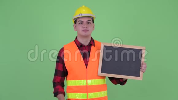 青年多民族建筑工人扶着黑板竖起大拇指视频的预览图