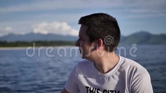 年轻人坐在一艘快艇上转往阳光明媚的岛屿视频的预览图