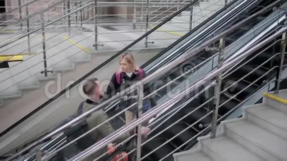 配偶一方正站在地下带行李的移动楼梯上视频的预览图