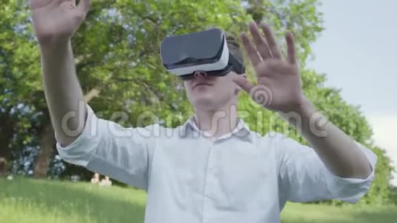 肖像青年戴虚拟现实耳机玩电子游戏享受现实形象未来主义和未来主义视频的预览图