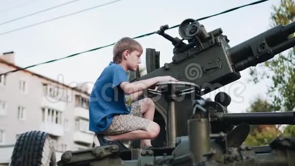 男孩控制着站在博物馆附近的高射炮视频的预览图