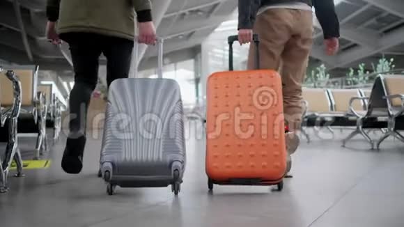 机场大厅里两个带着滚动手提箱的步行者的后景视频的预览图