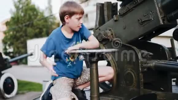 男孩坐在防空装置上转动控制装置不错的镜头视频的预览图