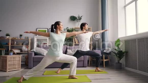 有魅力的年轻人女孩和男人在家做瑜伽练习体式视频的预览图