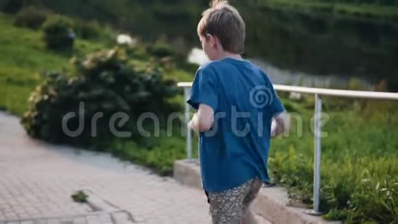 男孩在街上跑跳冷静开朗的男孩在城里走走视频的预览图