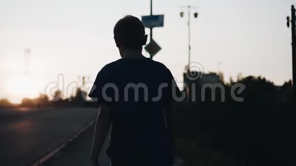 日落时男孩的酷画片那个男孩沿着海滨散步摄像机跟着他视频的预览图