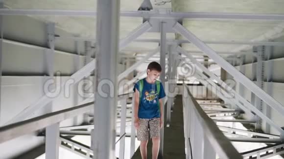 男孩走在桥下的技术结构上青少年生活视频的预览图