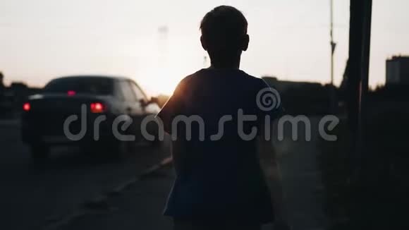 那个男孩在日落时在水边慢动作拍得不错光线不错傍晚漫步城市青少年视频的预览图