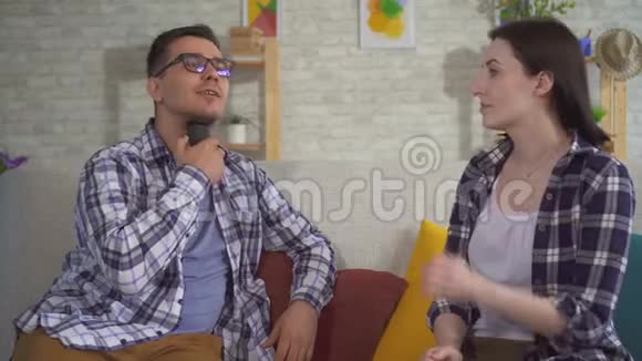一个男人和一个坐在沙发上的年轻女人交流用言语辅助韧带的问题视频的预览图