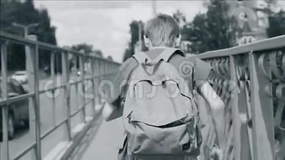 一个背着背包的男孩从桥上跑过去很酷的动态镜头播放缓慢情感上视频的预览图
