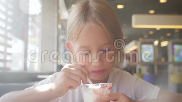 漂亮女孩在咖啡馆里吃冰淇淋孩子吃冰淇淋的生活方式理念视频的预览图