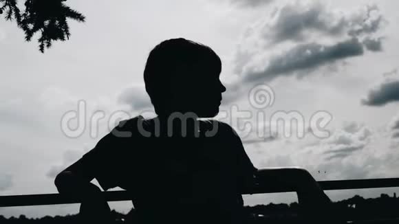 那个男孩站在海滨靠天一个男孩的剪影视频的预览图