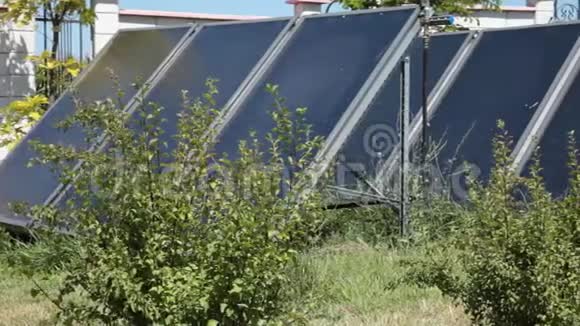 太阳能电池板在阳光明媚的一天在绿色花园里转换能源视频的预览图