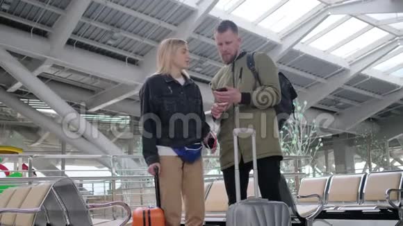 旅行者站在机场的大候车室里男人和女人视频的预览图