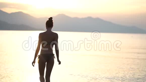 瘦小的女孩在日出时慢慢地出海游泳视频的预览图