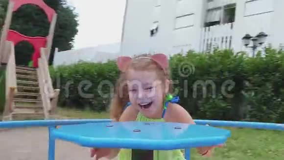 可爱的微笑女孩在旋转木马上玩得很开心视频的预览图