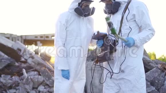 两名穿着防护服和面罩的科学家对个人电离辐射剂量计进行了测量视频的预览图