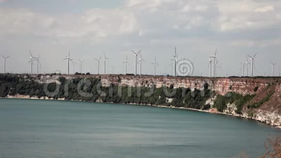 海边悬崖上的大型风车涡轮机提供能源全景视频的预览图