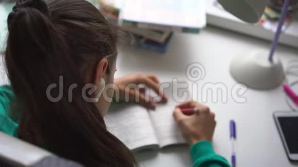 无线耳机的少女学生写家庭作业视频的预览图