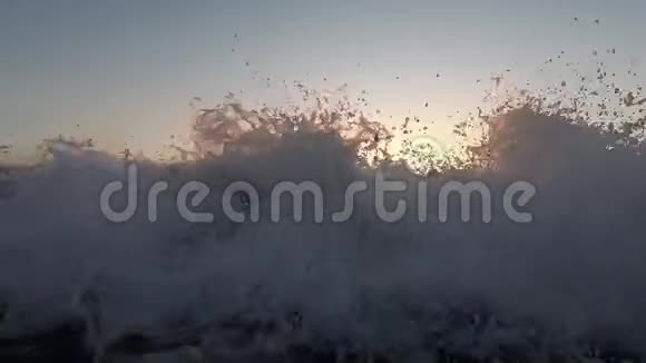 日落时海上海滩上的巨浪桑托里尼的慢动作视频视频的预览图
