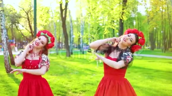 两名身着鲜艳服装表演民族舞的女舞者的镜头闪耀视频的预览图