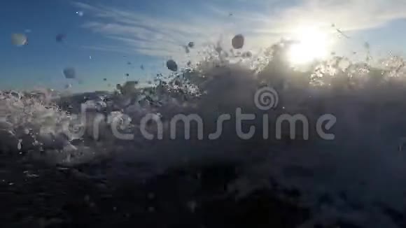 日落时海上海滩上的巨浪桑托里尼的慢动作视频视频的预览图