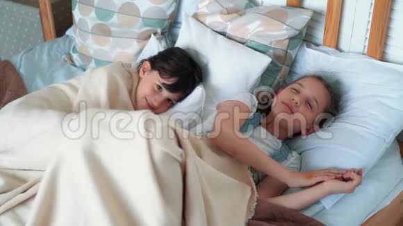 两个可爱的小女孩躺在床上笑着笑着慢动作视频的预览图