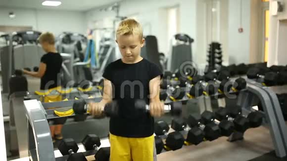 带着哑铃在健身房的男孩视频的预览图