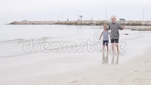 快乐的小女孩沿着海滨奔跑视频的预览图