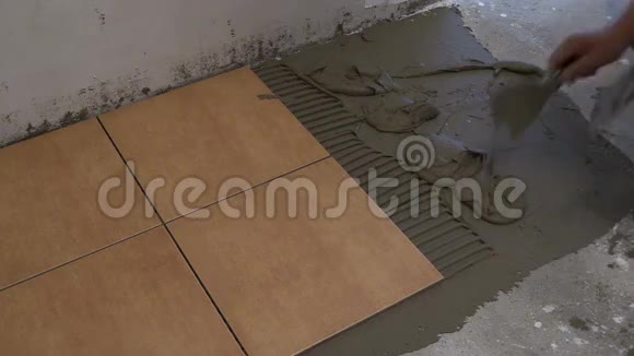 师傅手把瓷砖水泥胶放在地板上家庭改造视频的预览图