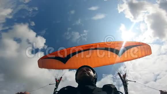 天空和那个拿着栏杆的人靠在上面空中滑翔伞活动视频的预览图