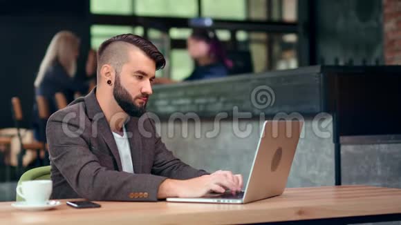 穿着便装的年轻时尚商务男士用笔记本电脑打字视频的预览图